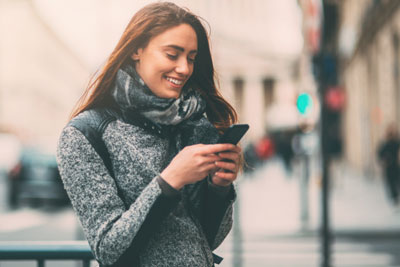 Woman checking luxy app on her phone and smiling