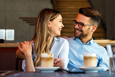 Man and woman smiling at each other on Tinder coffee date