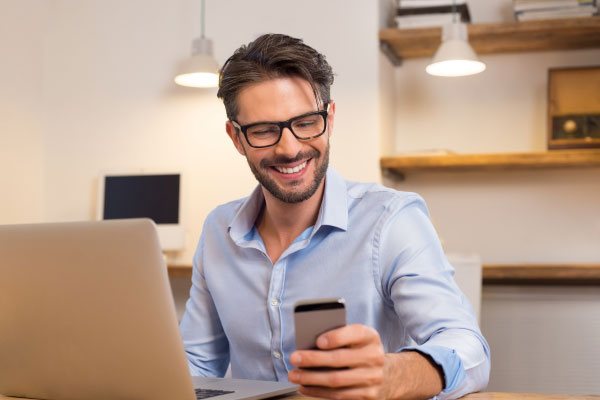 Man looking at dating app on mobile and smiling