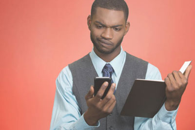 The Dating Terms You Need To Know In 2025 1 Confused looking man comparing phone to a book