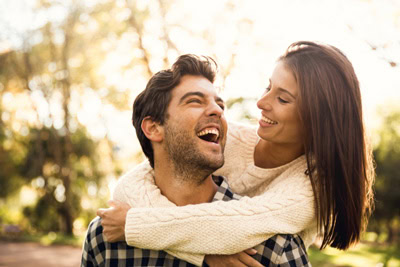 Happy Christian couple embracing outside in a park setting