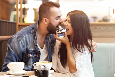 Man and woman sharing a donut on a Hinge date