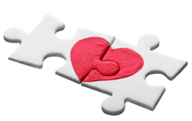 Puzzle pieces fitting together to form a heart.