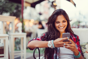 Woman smiling while using a dating app on her phone